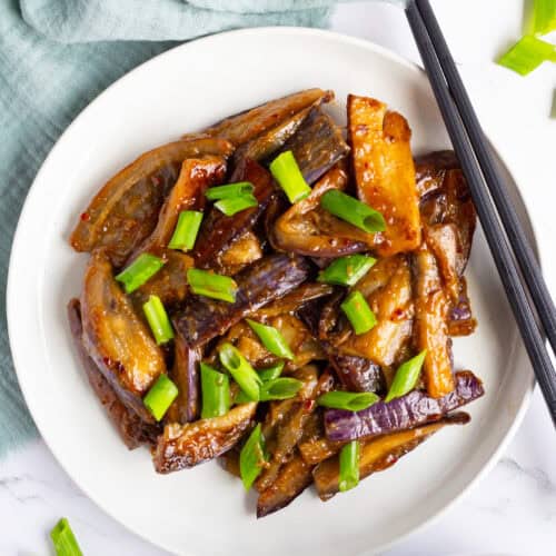 Plate of Chinese eggplant in garlic sauce with a set of chopsticks on the side.