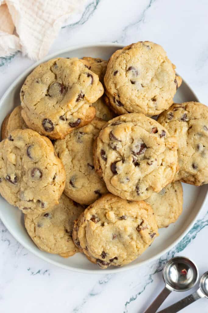 A white plate filled with hazelnut chocolate chip cookies.