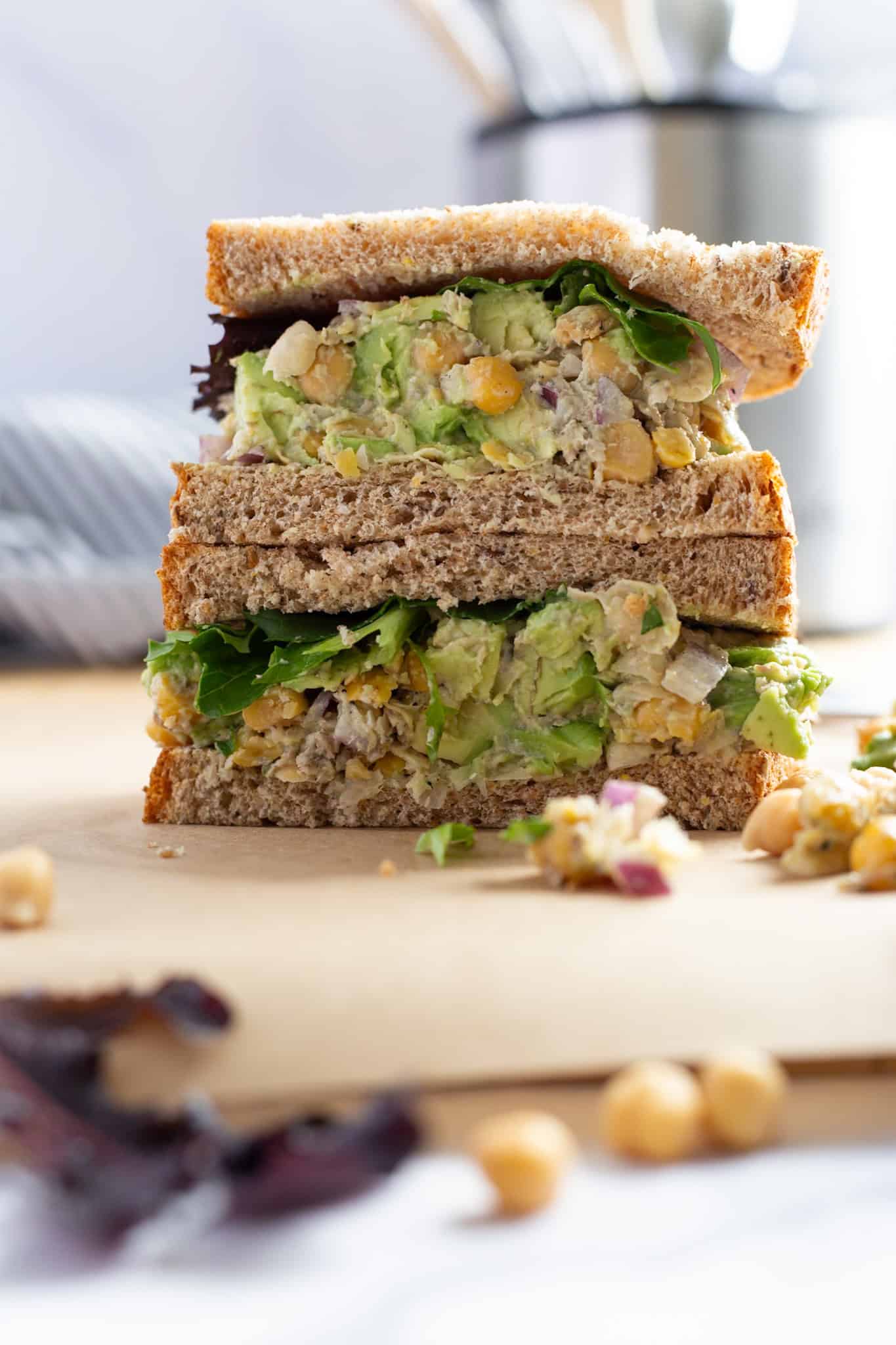 A stacked sandwich of smashed chickpeas, avocado, and sardines.