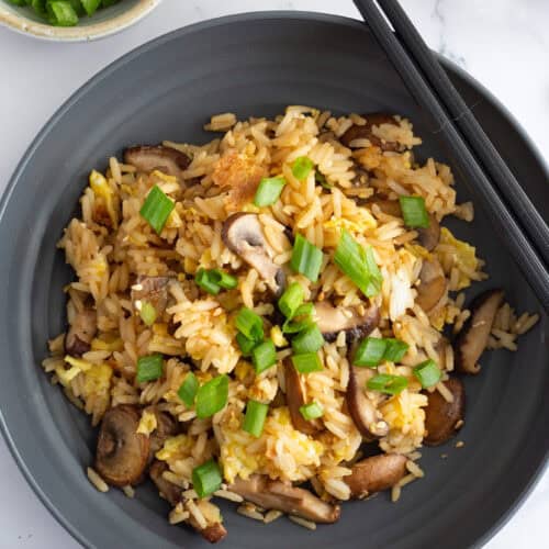 A plate of miso fried rice with mushrooms, with chopsticks on the side.