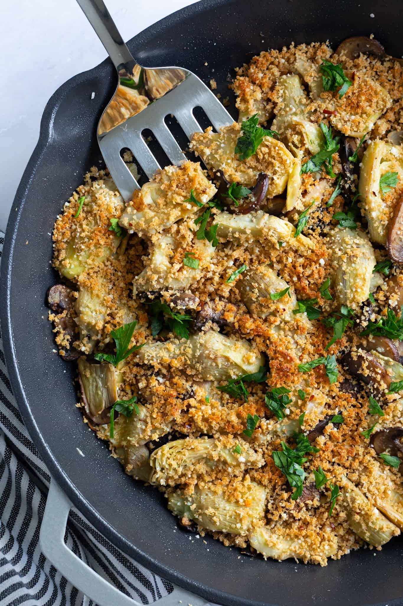 A pan of artichoke hearts with Parmesan breadcrumbs.