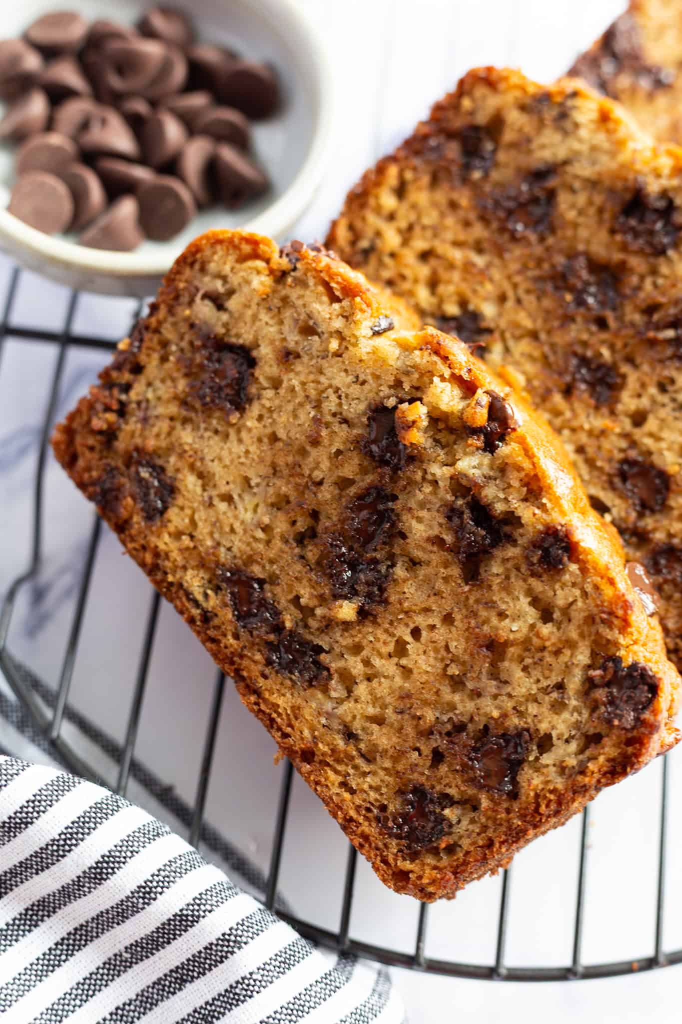 Sliced chocolate chip banana bread with 2 bananas.