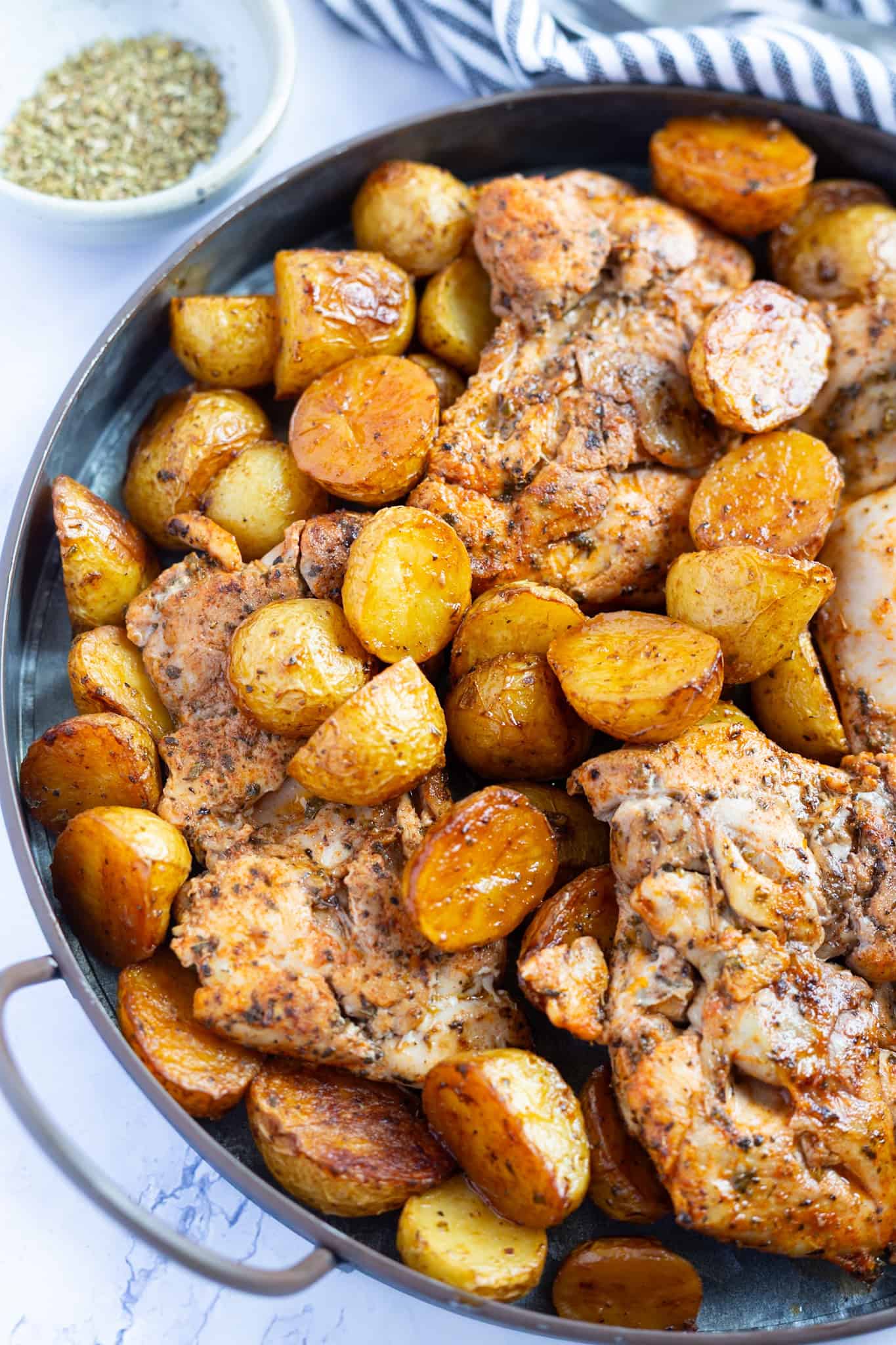 A platter of a baked vinegar chicken recipe with potatoes.